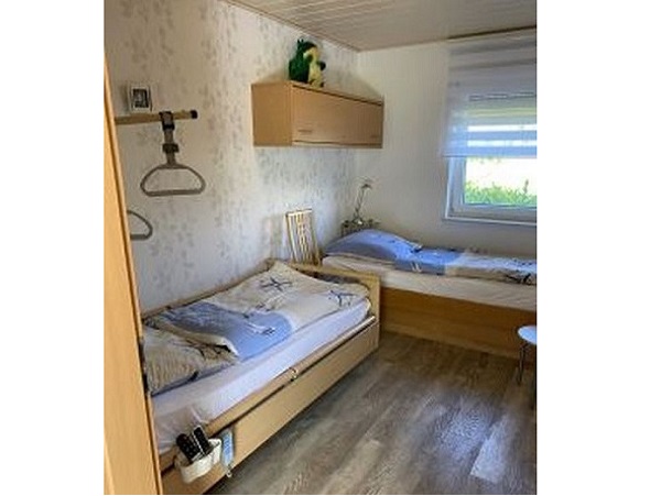 schlafzimmer mit höhenverstellbaren pflegebett und Einzelbett